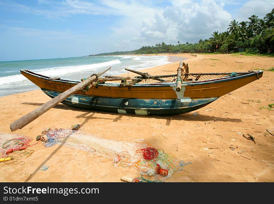 Fishers boat on sand of coastline at sunny day