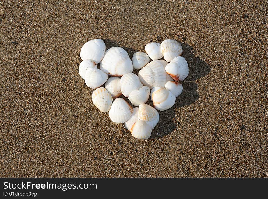 Heart made of white shells on the sea beach. Heart made of white shells on the sea beach.