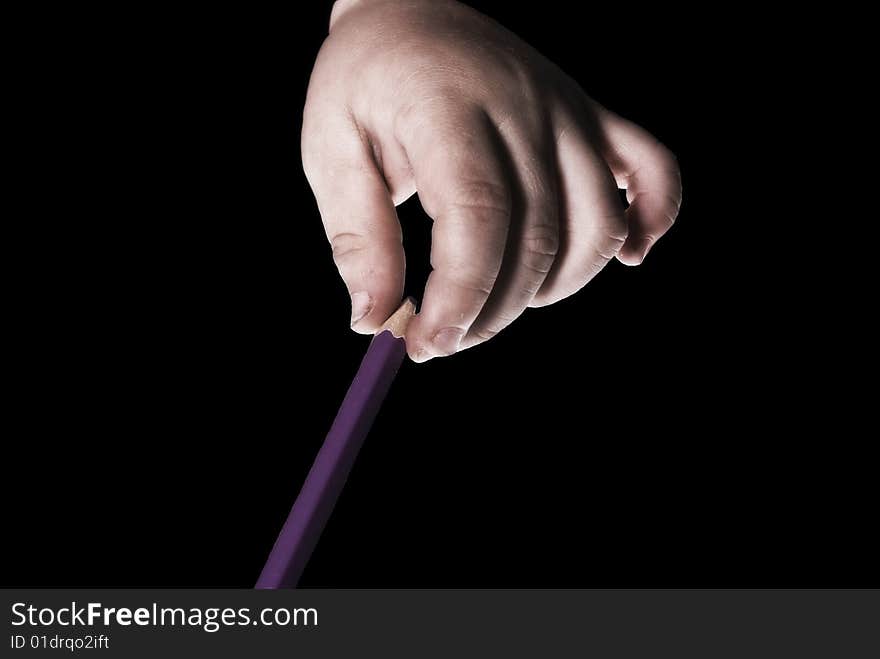 One boys hand holding a penn with a black background.