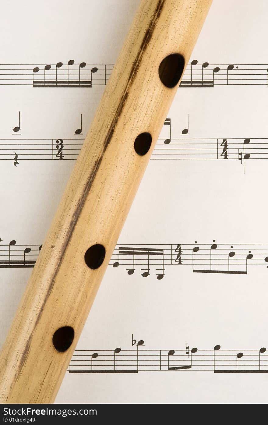 Hand made bamboo flute sits on a sheet of music