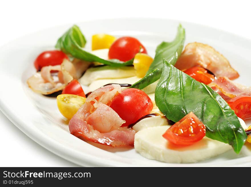 Salad with Cherry Tomato, Buffalo Cheese, Bacon and Vegetable Leaf. Isolated on White Background. Salad with Cherry Tomato, Buffalo Cheese, Bacon and Vegetable Leaf. Isolated on White Background