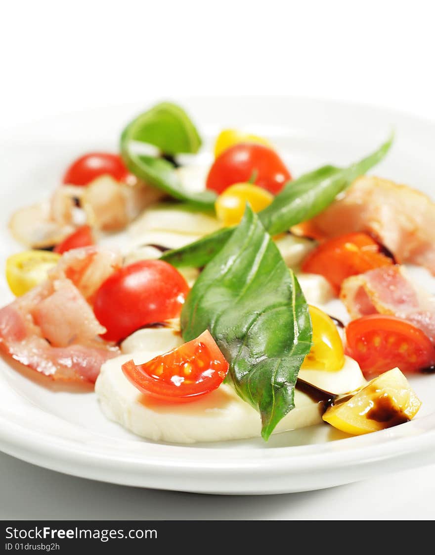 Salad with Cherry Tomato, Buffalo Cheese, Bacon and Vegetable Leaf. Isolated on White Background. Salad with Cherry Tomato, Buffalo Cheese, Bacon and Vegetable Leaf. Isolated on White Background