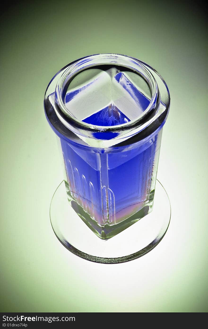 Laboratory glass beaker filled with a blue chemical solution, isolated, vignette.