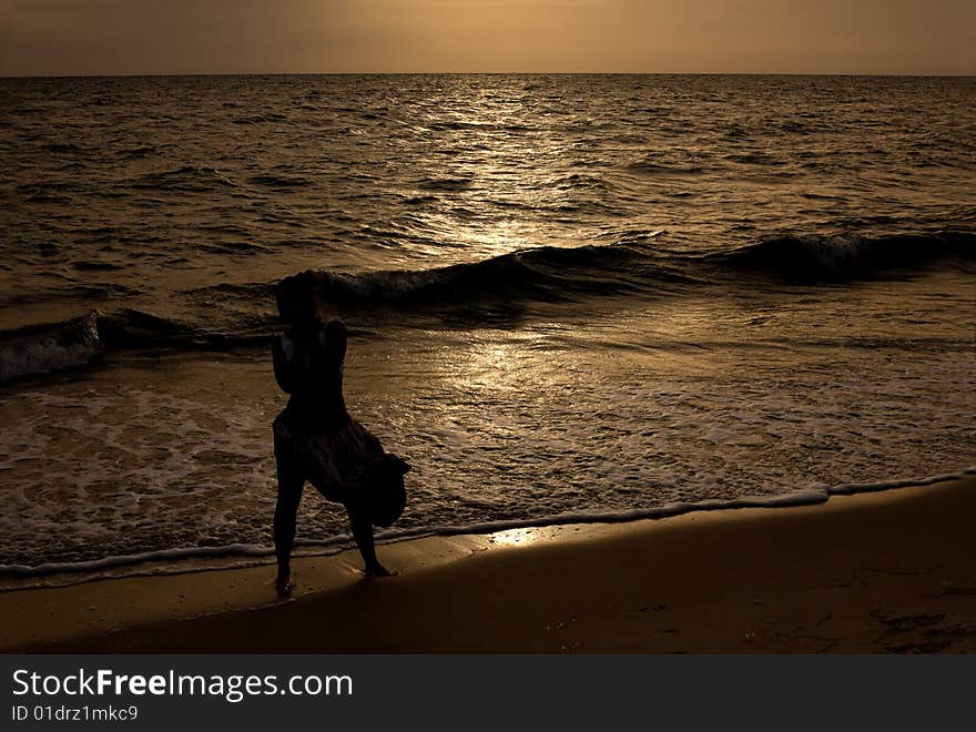 Silhouette of girl on sunset beach