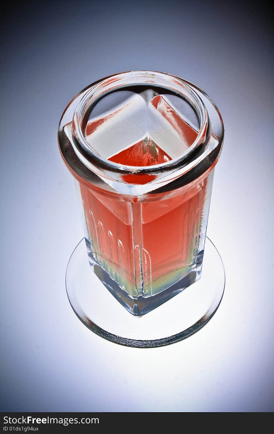 Laboratory glass beaker filled with red chemical solution, isolated, vignette.