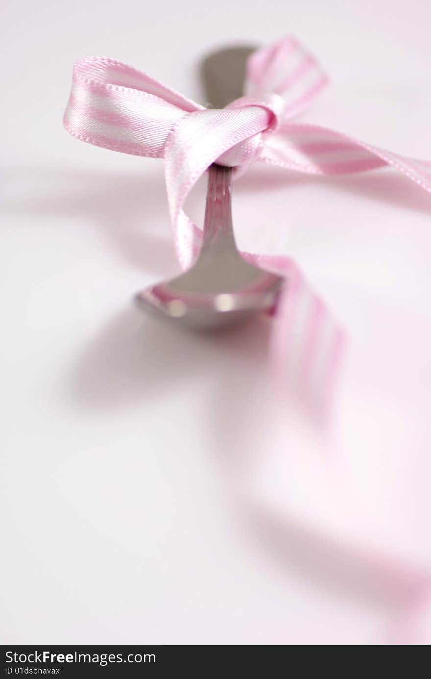 Studio shot of a tea spoon with decorative ribbon. Studio shot of a tea spoon with decorative ribbon