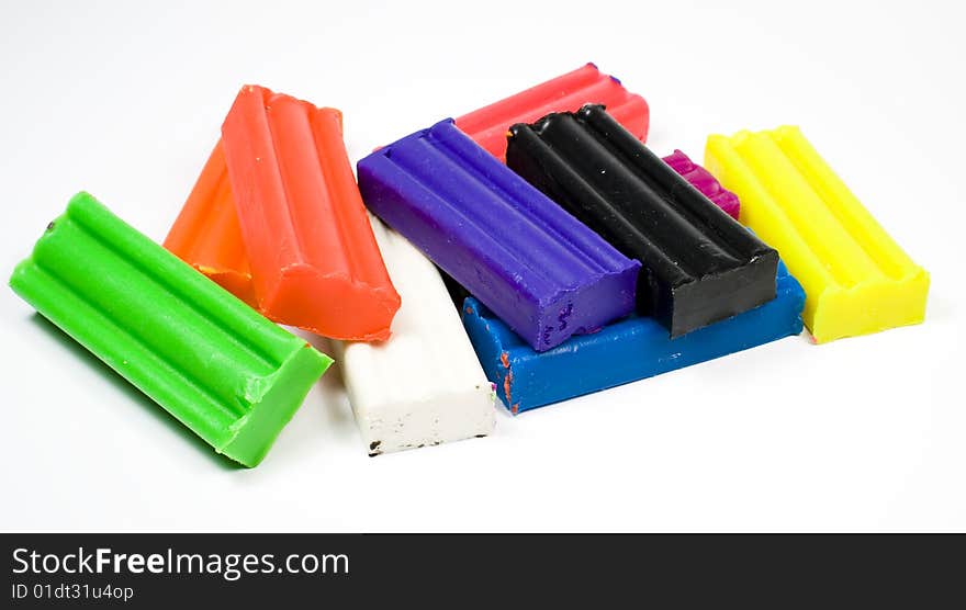 Plasticine, several different colours, on white background