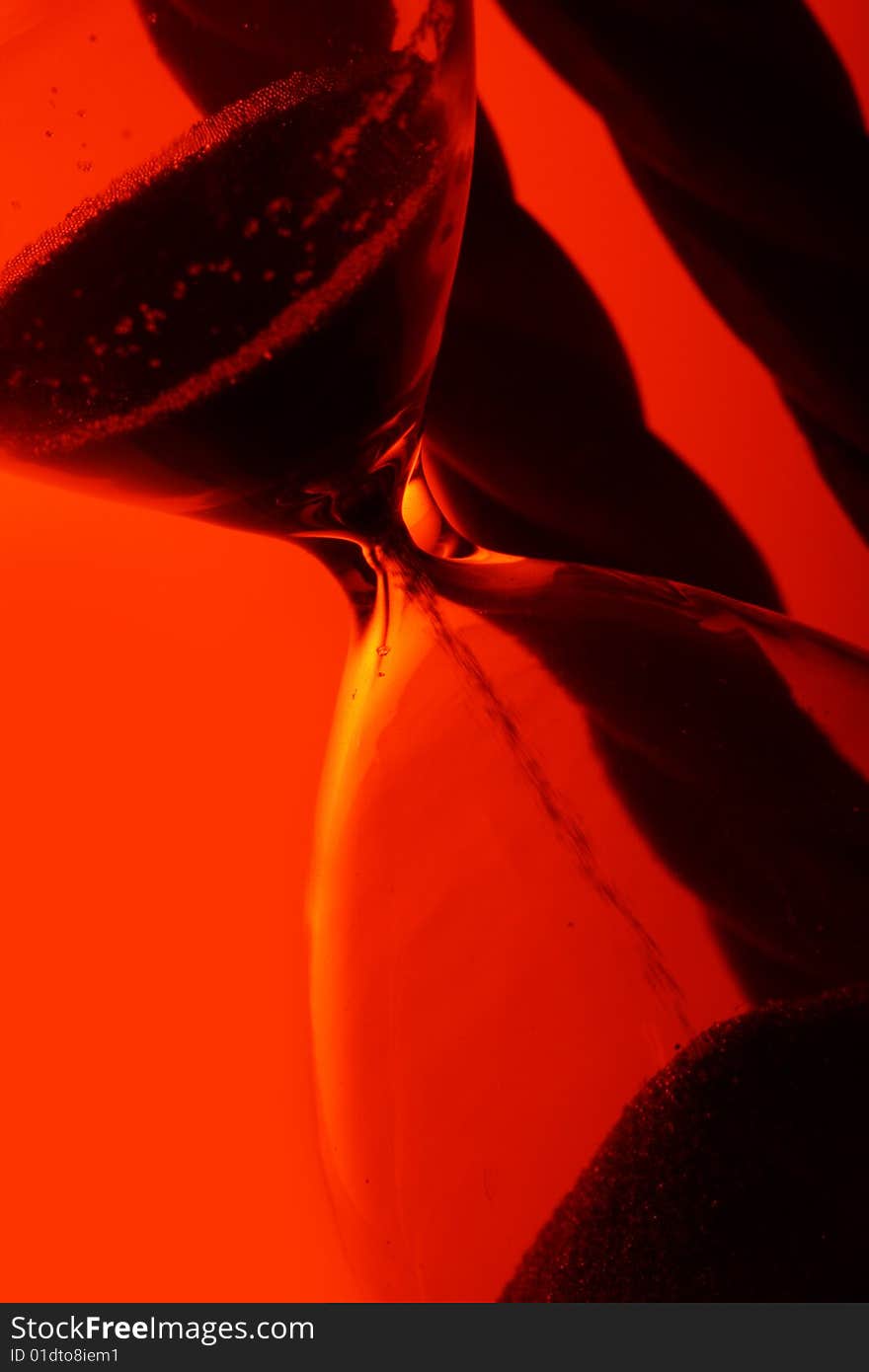 Hourglas in red light close-up. Hourglas in red light close-up