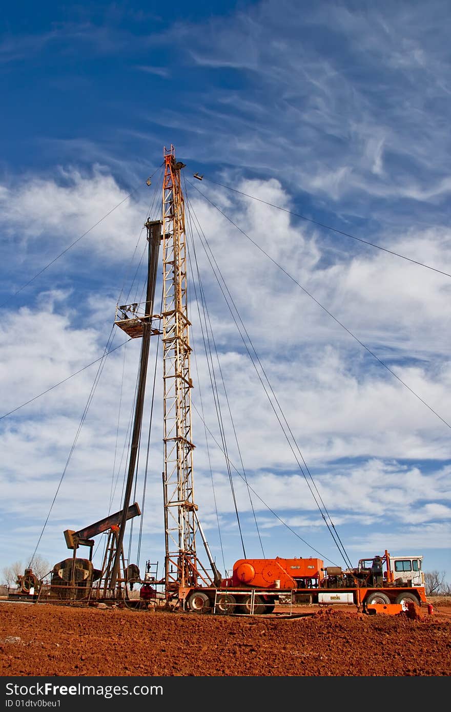 Oil Field Pulling Unit installing new sucker rods in an oil well