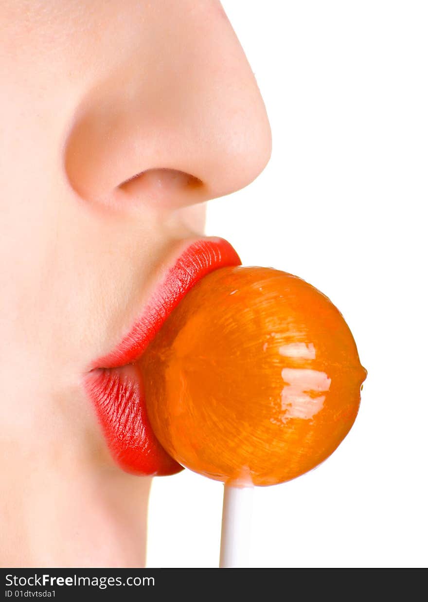 A woman with the brightly painted lips sucks a lollipop candy. Shallow DOF.