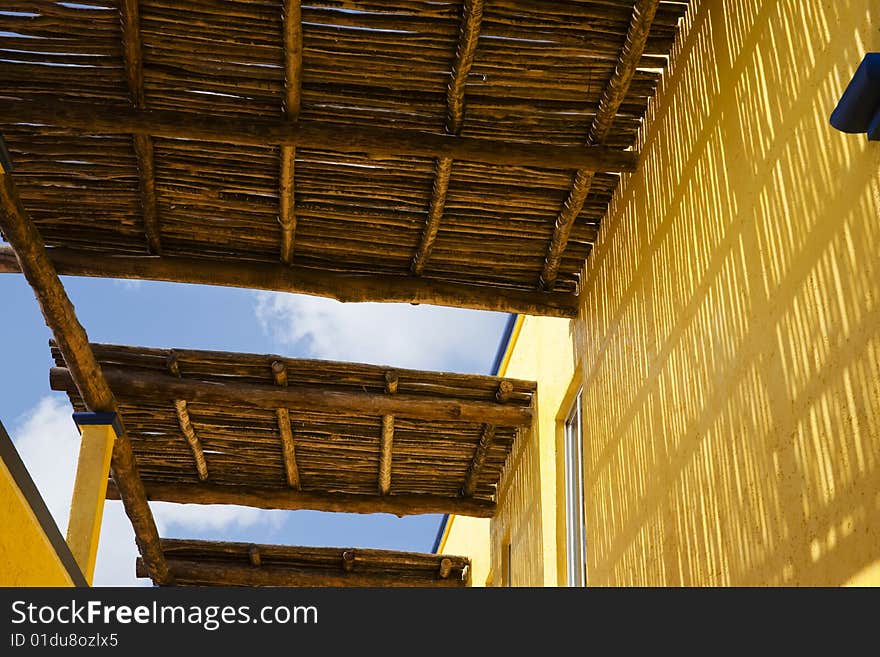 A wooden roof with a yellow wall in a Caribbean resort