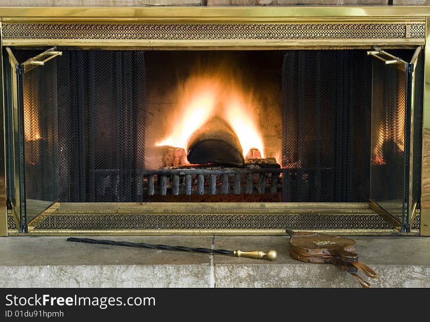 Classic fireplace with bellows and a poker ready for assistance. Classic fireplace with bellows and a poker ready for assistance.