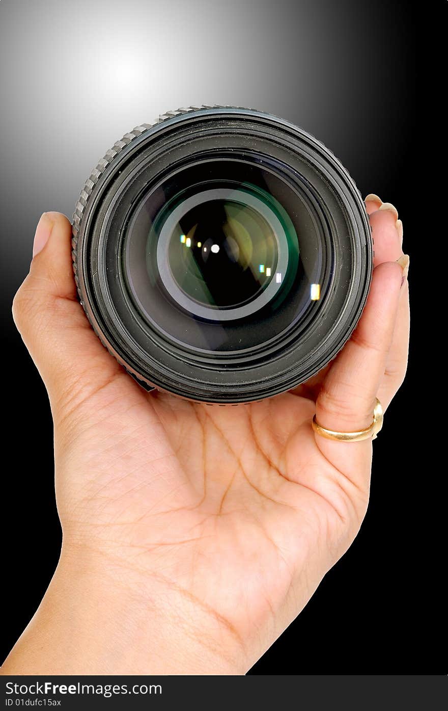 Female hand holding a camera lense.