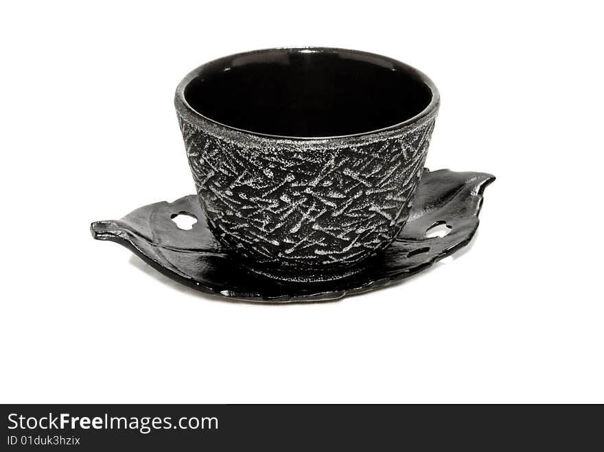 Black teacup on leaf saucer