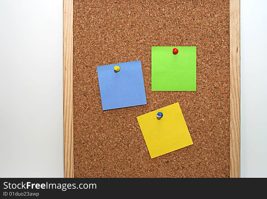 Cork board in white background, with colored notes. Cork board in white background, with colored notes