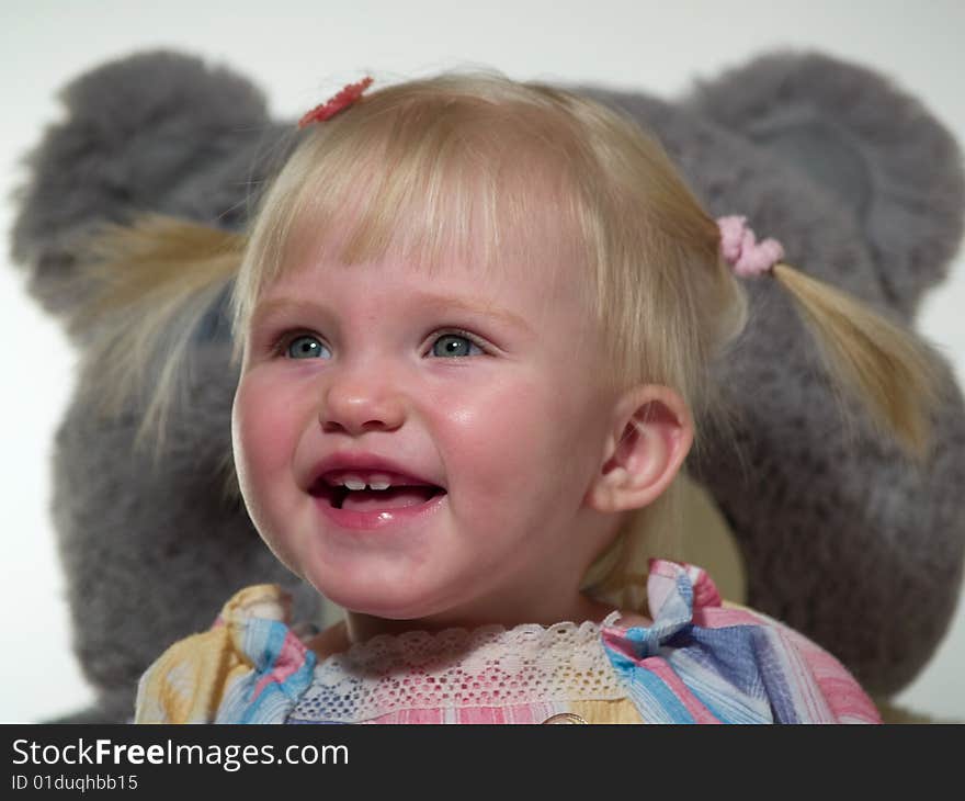 Beauty child smiles near toys