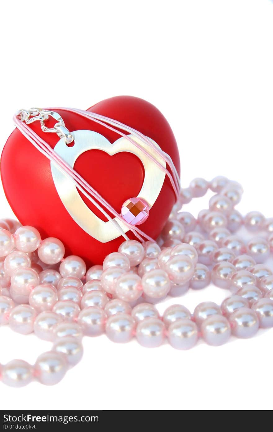 Valentine hearts and pink pearls on white background.