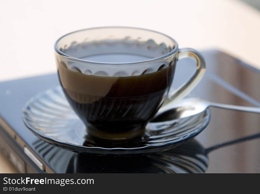 Espresso coffee cup with steel spoon on the laptop