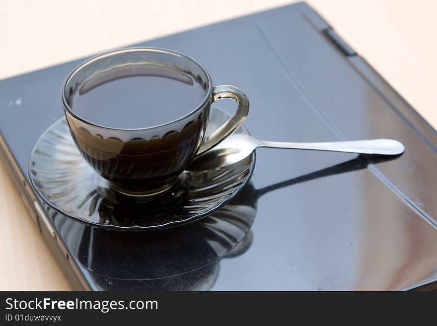 Espresso coffee cup with steel spoon on the laptop