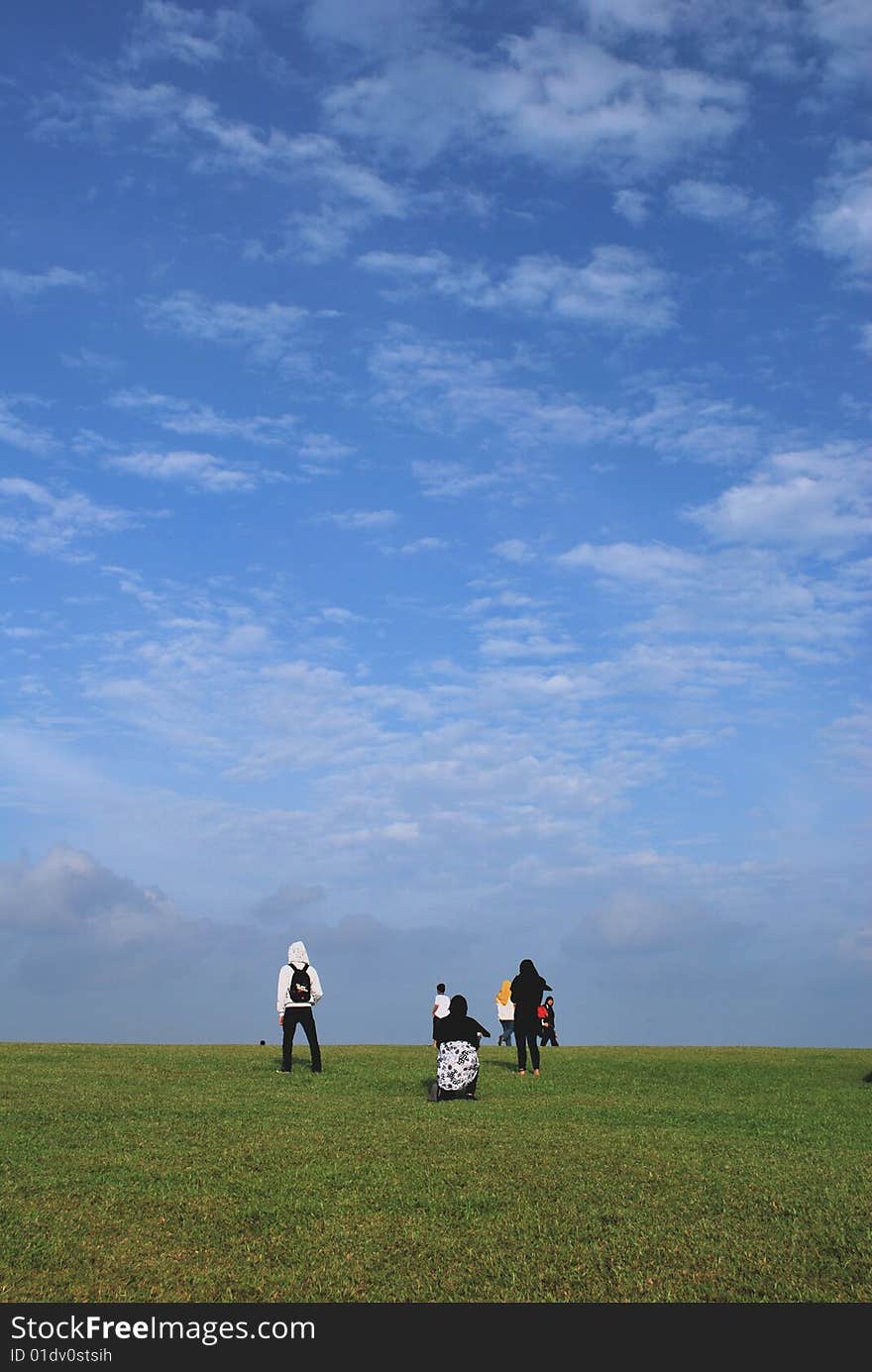 A group of Malays wearing their traditional headgear in a field relaxing and enjoying the beautiful blue skies. A group of Malays wearing their traditional headgear in a field relaxing and enjoying the beautiful blue skies.