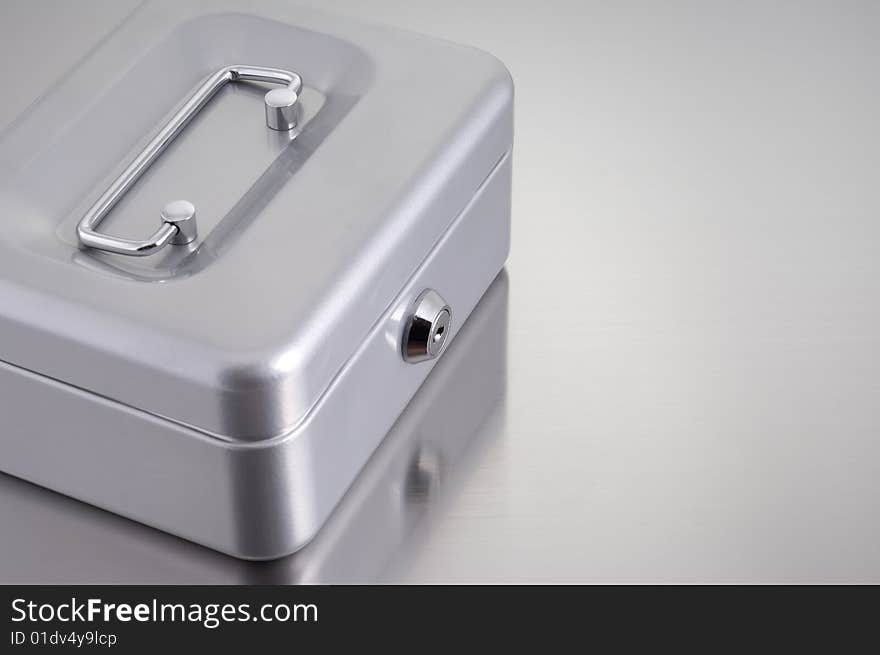 Metal cash box on metallic background