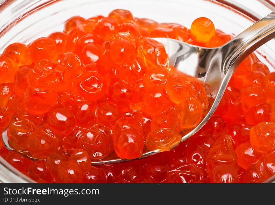 The spoon and red caviar in glass can