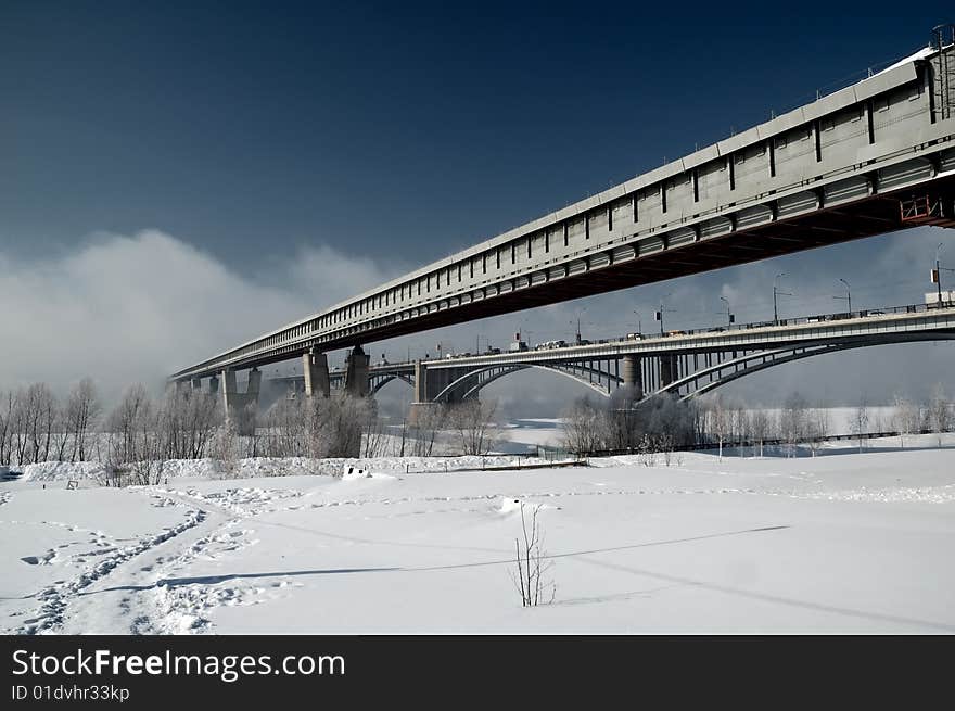 Two bridges through the river vanish in fog