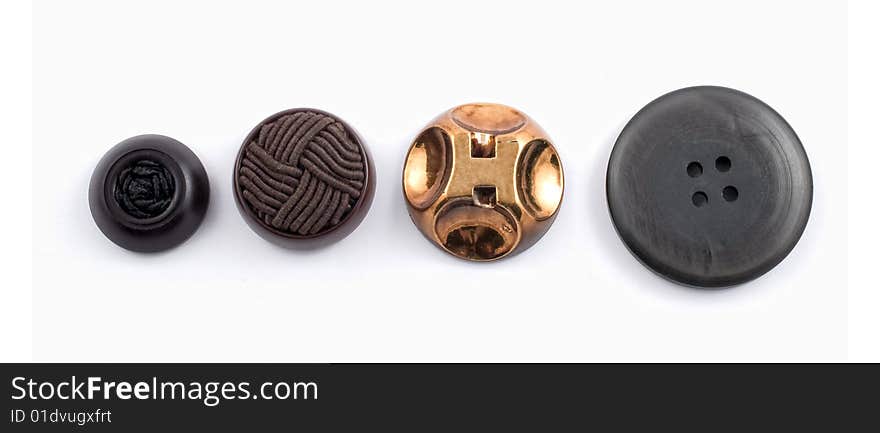 Four assorted buttons in a row on white background