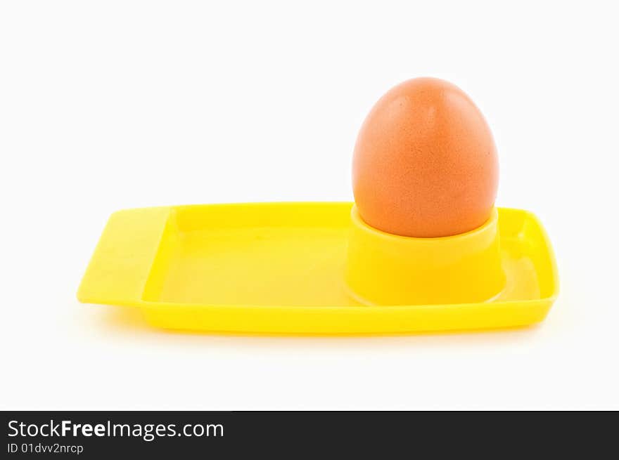 Egg in yellow egg holder isolated on white