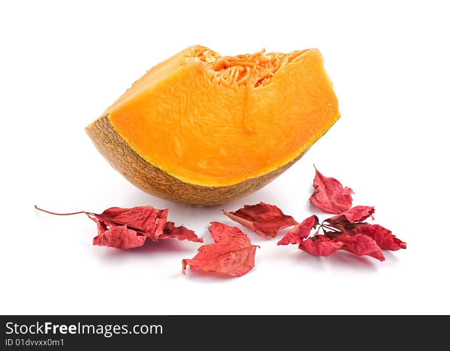 Slice of pumpkin with red autumnal leaves isolated on white