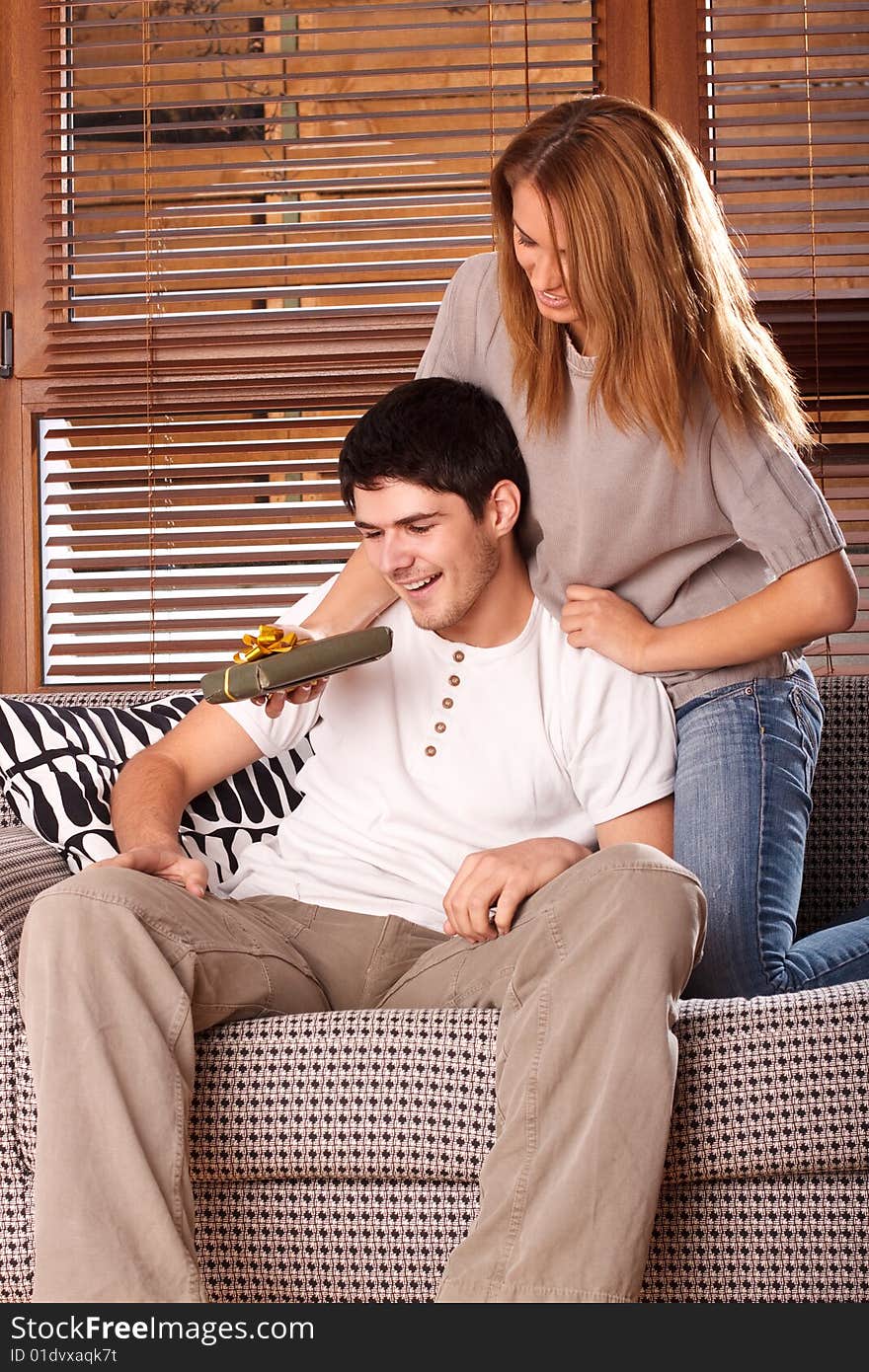 Young couple exchanging presents, shot with studio lights