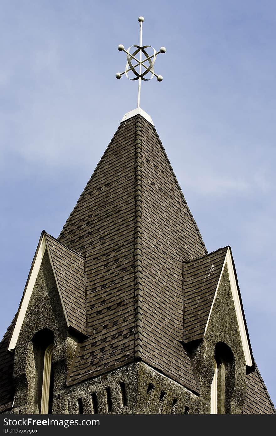 A traditional church steeple against partly cloudy sky. A traditional church steeple against partly cloudy sky