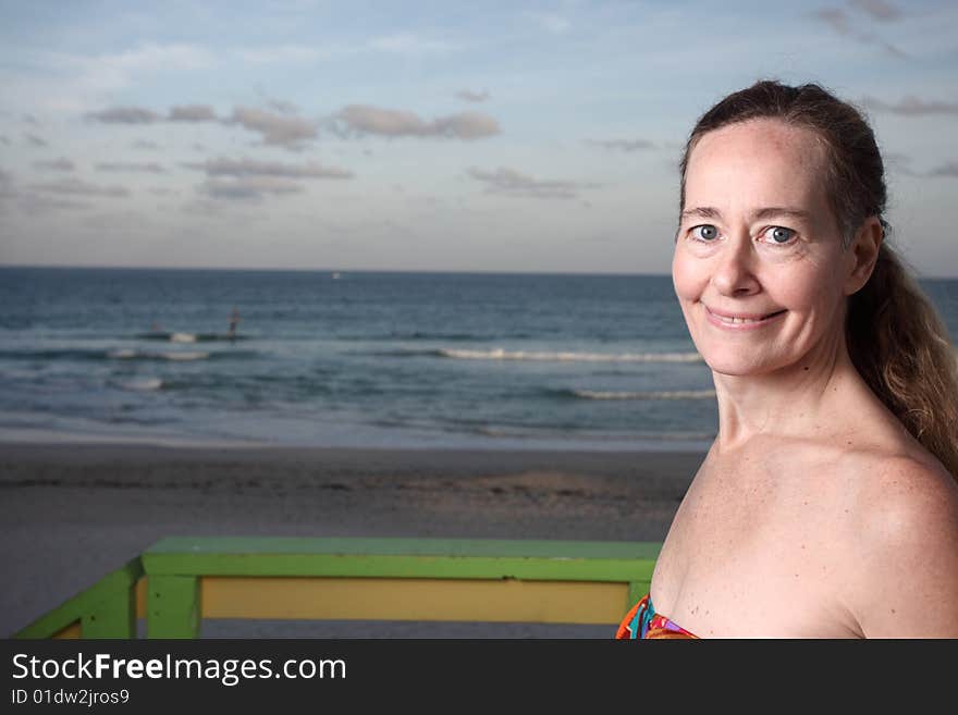 Woman smiling with the ocean in the background. Woman smiling with the ocean in the background