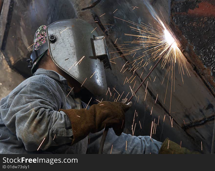 A metal welder busy at work. A metal welder busy at work