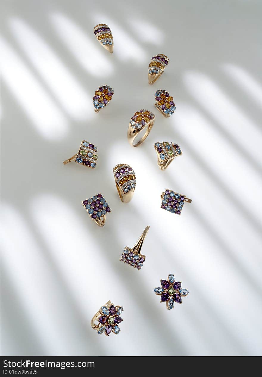 Golden jewelry with colored stones on a white background