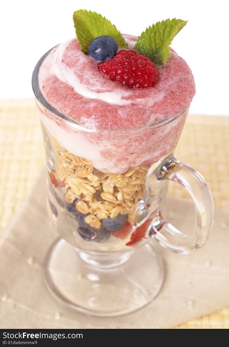 Healthy breakfast with muesli, raspberries, blueberries and yoghurt, decorated with mint leaves in a glass. Healthy breakfast with muesli, raspberries, blueberries and yoghurt, decorated with mint leaves in a glass