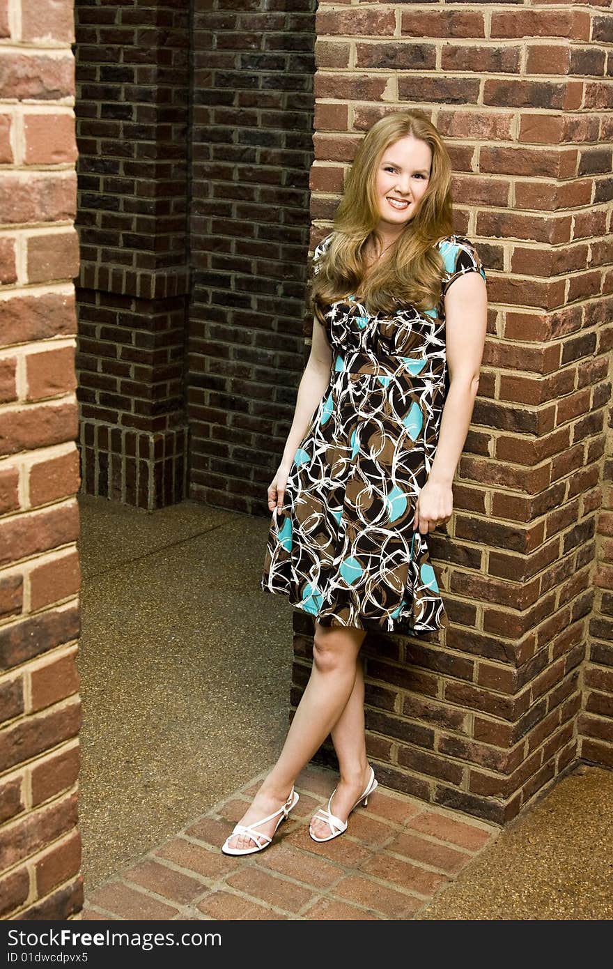 Young Woman with Happy Expression Standing Against Brick Background. Young Woman with Happy Expression Standing Against Brick Background