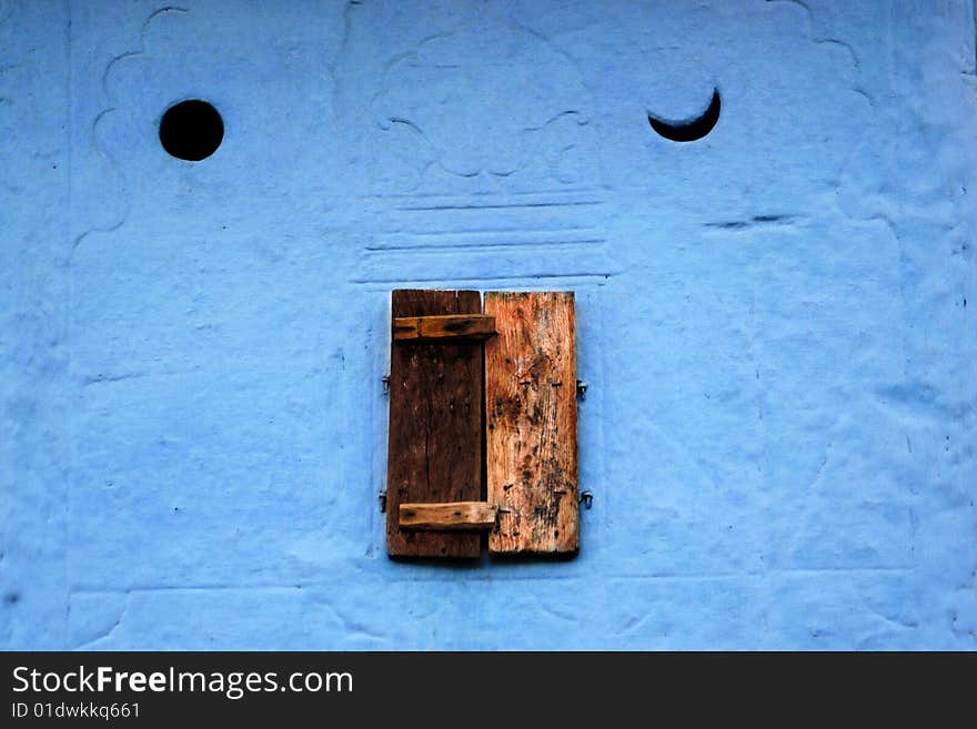 Little close window and blue wall with sun and moon symbols, Rajasthan, India. Camera: Nikon D70 with Sigma 70-300 mm