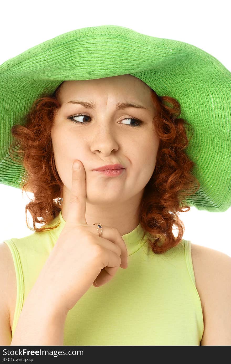 Thoughtful young woman with ginger hair wearing a green summer hat