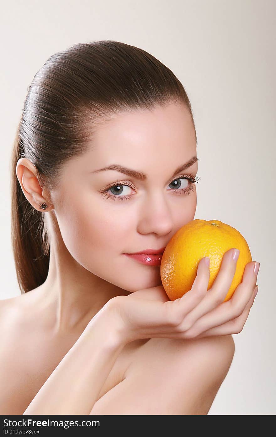 Attractive Woman Holding Orange In Studio