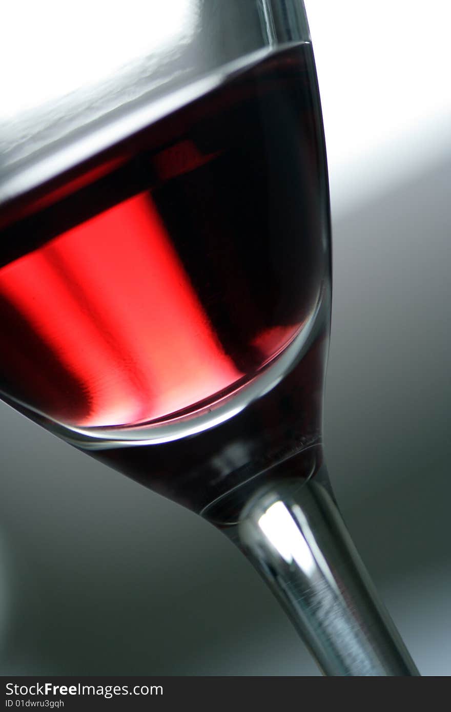 Glass with red wine. A fragment. Accent on color of wine.