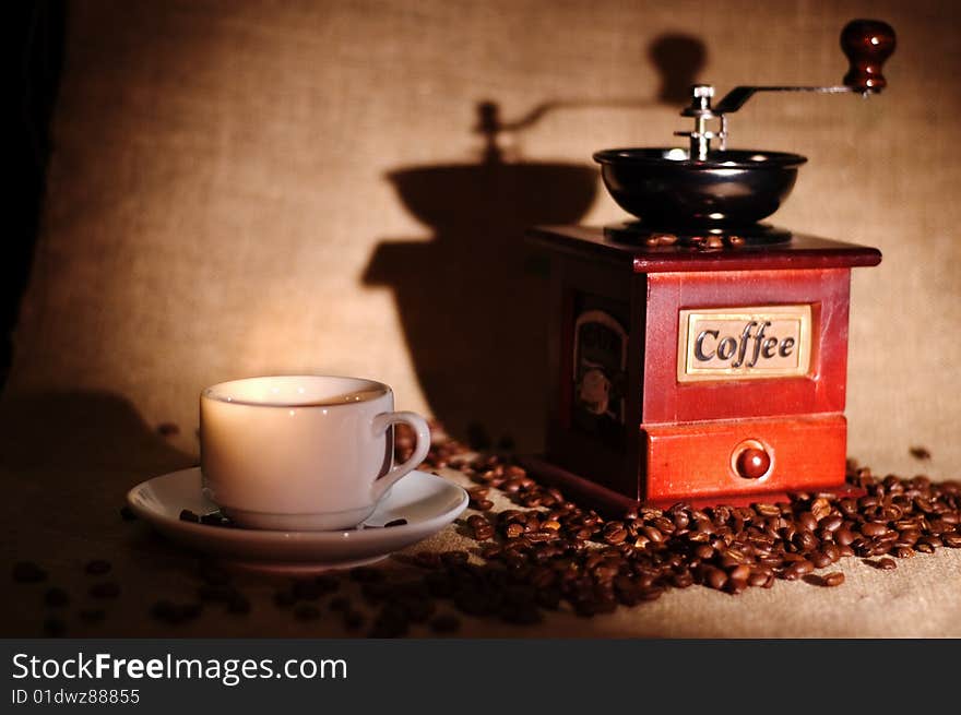 Still life with cup of coffee and coffee-mill on the sack