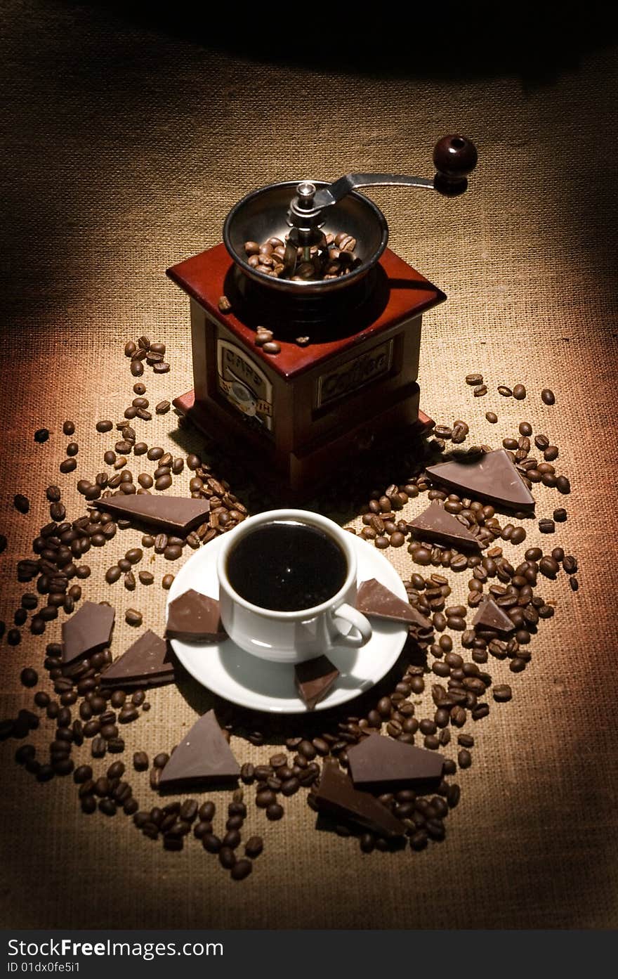 Still life with cup of coffee and coffee-mill on the sack