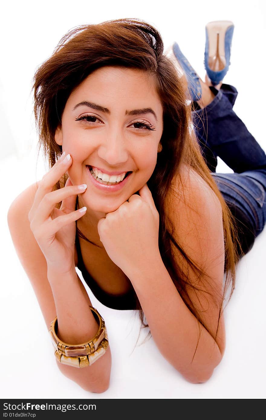 Front view of smiling young woman holding her face with white background