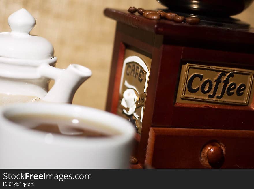 Still life with cup of coffee and coffee-mill on the sack