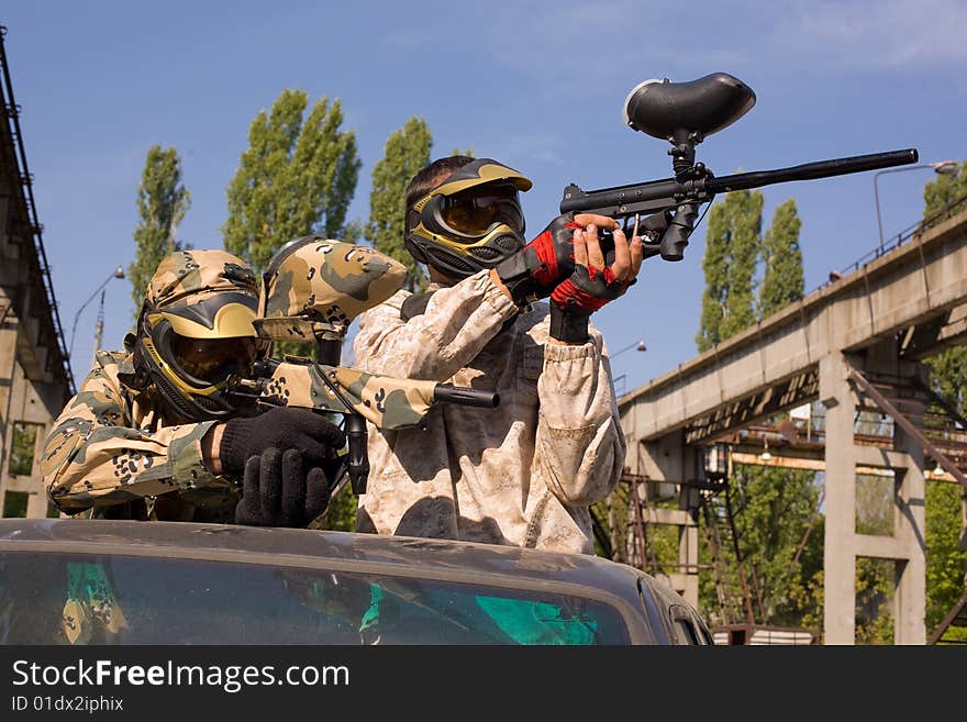 Two paintball players on the car