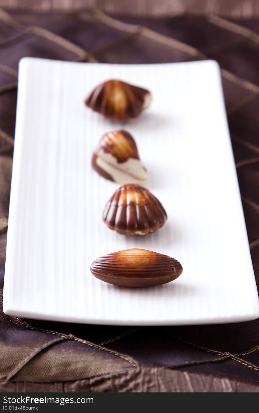 Four assorted chocolates laid out on a plate. Four assorted chocolates laid out on a plate