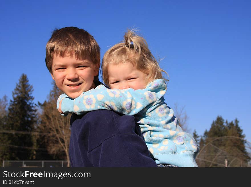 Older brother giving younger sister a piggy back ride. Older brother giving younger sister a piggy back ride