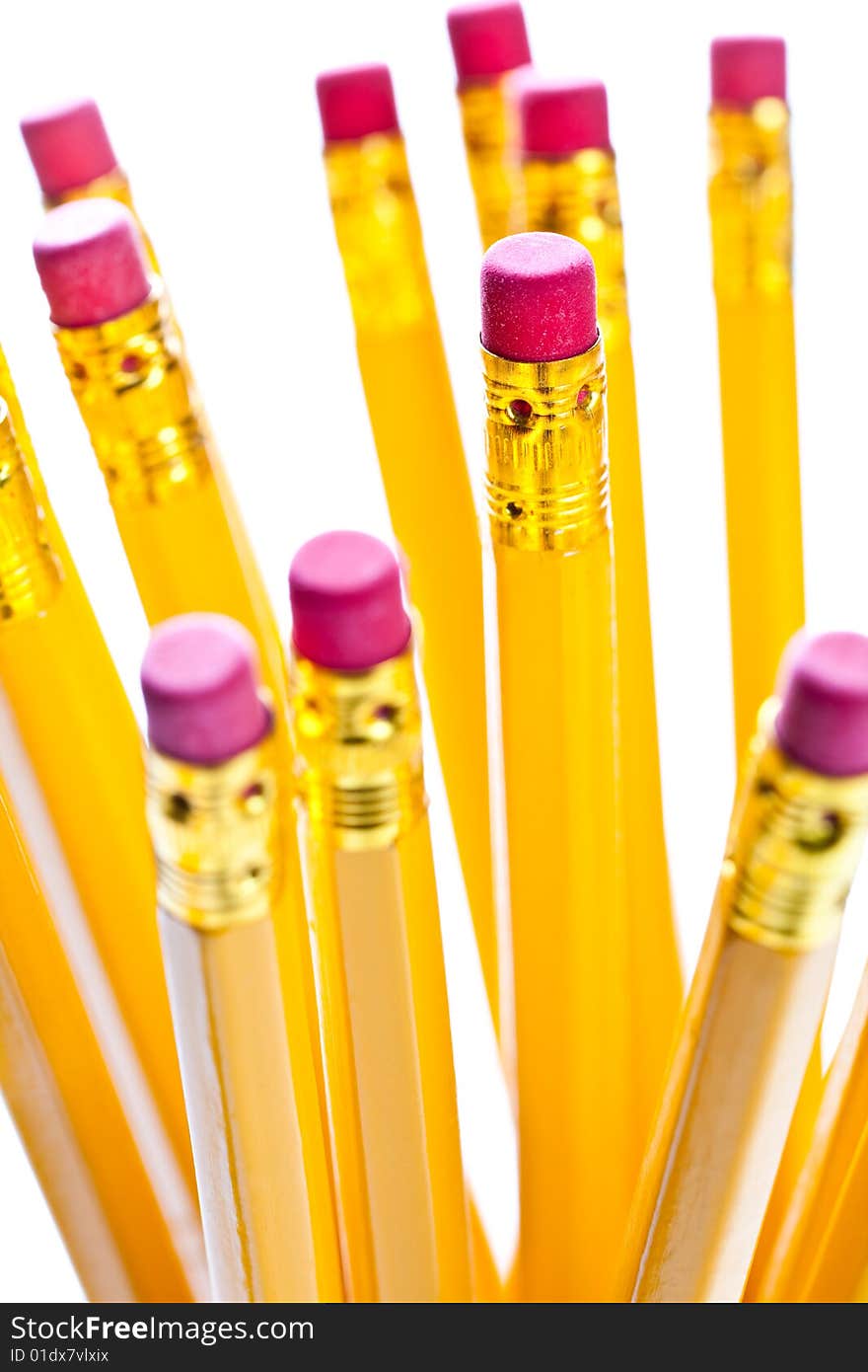 Yellow pencils with a rubber on the end in a glass