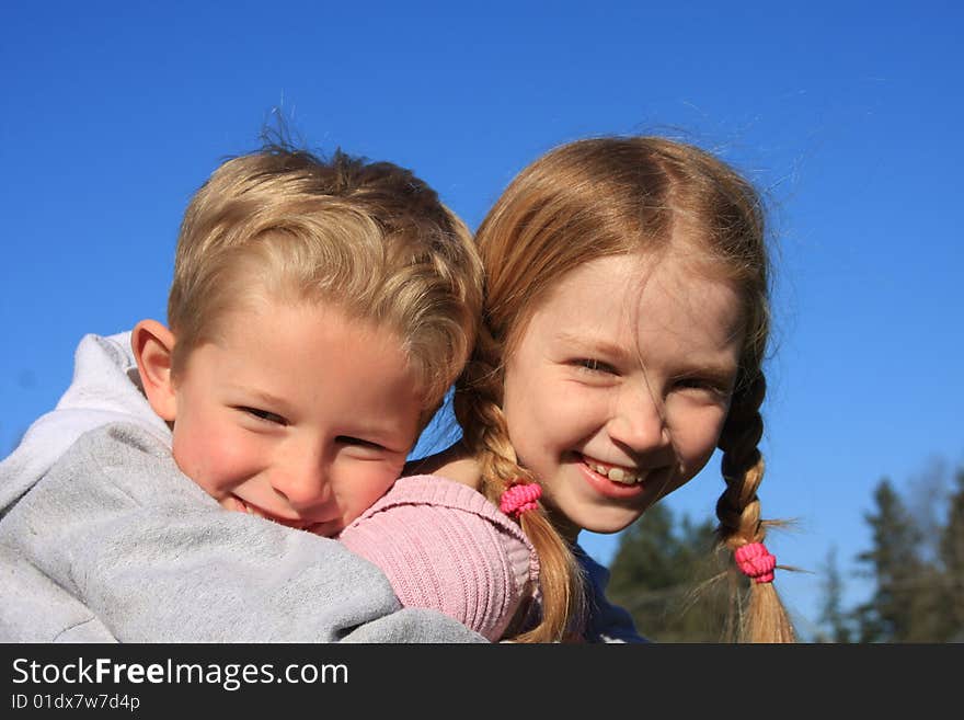 Bigger sister giving little brother a piggy back ride. Bigger sister giving little brother a piggy back ride